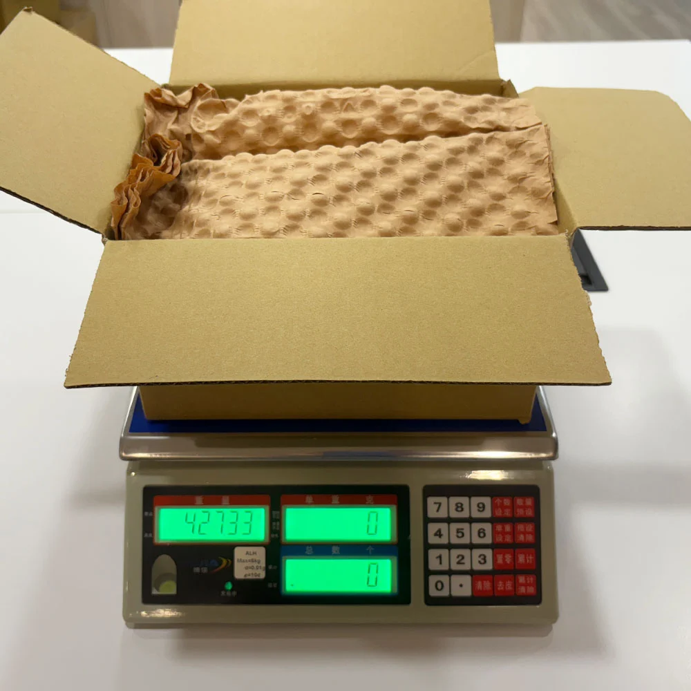 使用原生紙材進行填充後的出貨重量測量畫面，顯示在相同防護需求下整體重量為427.33克，反映實際使用量增加的情況